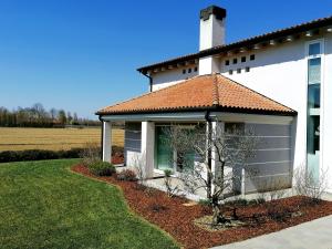 a white house with a tree in the front yard at Ca' Belvedere in Sant'Elena di Silea