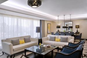 a living room with two couches and a table at voco - Riyadh, an IHG Hotel in Riyadh