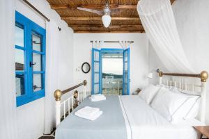 a white bedroom with a bed and a blue window at Exquisite estate, serene environment in Lefkes