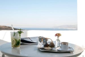 uma mesa com um prato, um copo e uma bebida em Exquisite estate, serene environment em Lefkes