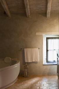 a bathroom with a toilet and a window and towels at Relais Del Maro in Borgomaro