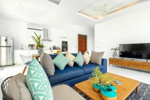 a living room with a blue couch and a table at Villa Claire - Seaview Private Villa in Bophut