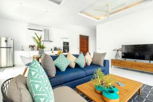 a living room with a blue couch and a table at Villa Claire - Seaview Private Villa in Bophut 