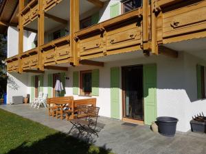 Casa con terraza de madera, mesa y sillas en Ferienwohnung Am Kirchberg, en Achslach