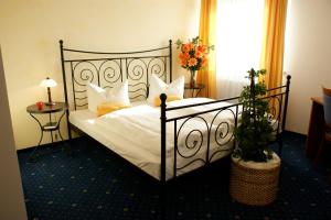 a bedroom with a bed with white sheets and pillows at Hotel Haslbach FGZ in Regensburg