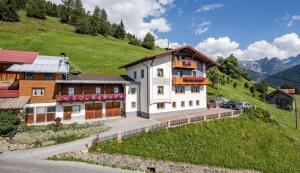 um grande edifício branco numa colina com uma casa em Biohof-Inntalblick em Kaunerberg