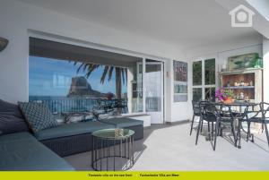 a living room with a couch and a table and chairs at Solhabitat Coll de Mar in Calpe
