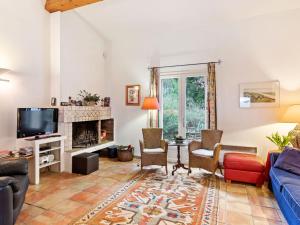sala de estar con sofá y TV en Lavish Villa in Bagnols en For t with Swimming Pool, en Bagnols-en-Forêt