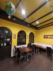 a dining room with tables and chairs and a yellow wall at 水里河堤咖啡民宿 Shuili Heti coffee B&B in Shuili