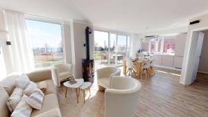 sala de estar con sofá, sillas y mesa en Beach'n'Sea Wohnung 9 en Grömitz