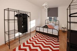 a bedroom with a bed and a red and white rug at stylish city apartment in Zwickau in Zwickau