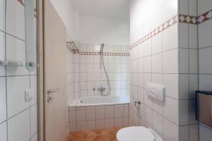 a bathroom with a tub and a toilet and a sink at stylish city apartment in Zwickau in Zwickau
