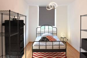 a bedroom with a metal bed with a red and white rug at stylish city apartment in Zwickau in Zwickau