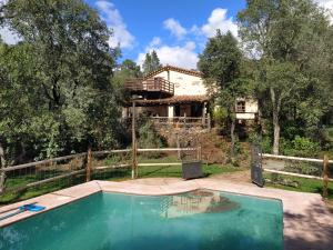 una casa con piscina frente a una casa en CASA LA INDIANA, en Fuenteheridos