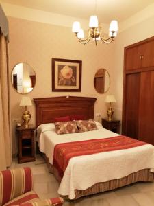 セビリアにあるホテル ヨーロッパ ブティック セビリアのベッドルーム1室(大型ベッド1台、鏡2つ付)
