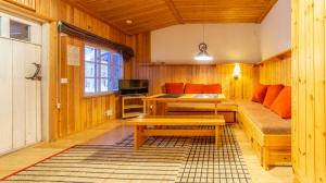 - un salon avec un canapé et une table dans l'établissement Kuukkeli Apartments Tokka, à Saariselka