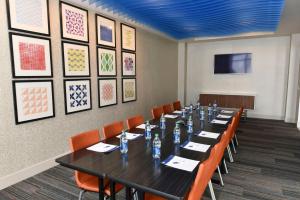 a conference room with a long table and orange chairs at Holiday Inn Express & Suites - Madisonville by IHG in Madisonville +31 photos