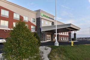 a building with a christmas tree in front of it at Holiday Inn Express & Suites - Madisonville by IHG in Madisonville