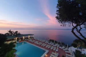 a view of a swimming pool with chairs and the ocean at Le Querce Resort Sea Thermae & Spa in Ischia