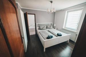 a bedroom with a white bed and a large window at Hotel und Pension Al Dente in Nünchritz