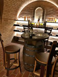 a wine cellar with a table and chairs and wine bottles at OPILÝ SKLEP in Velké Pavlovice