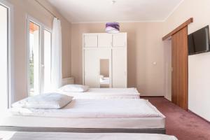 two beds in a bedroom with a tv on the wall at Resort Niegocin in Wilkasy +68 photos