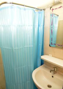 a bathroom with a blue shower curtain next to a sink at Bel Appart F3, Koumassi, proche aéroport d'Abidjan in Koumassi