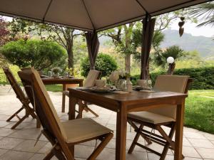 einen Holztisch und Stühle unter einem Sonnenschirm in der Unterkunft L'Acacia B&B in Pietra Ligure