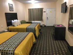 a hotel room with two beds and a tv at Homegate Inn & Suites West Memphis in West Memphis