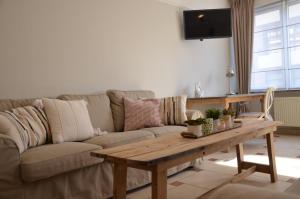 sala de estar con sofá y mesa de madera en Ciepers Lodge en Ypres