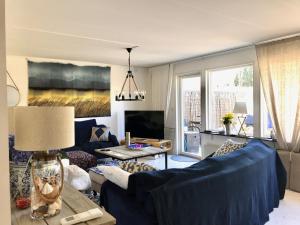 uma sala de estar com um sofá azul e uma mesa em Holiday Home Liden em Båstad