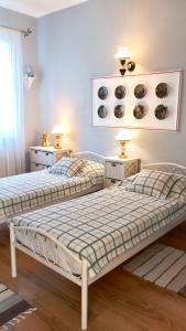 two beds in a room with two tables and two lamps at Parasolka in Odesa