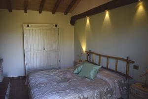1 dormitorio con 1 cama con cabecero de madera y puerta en Selva degli Ulivi, en Foiano della Chiana