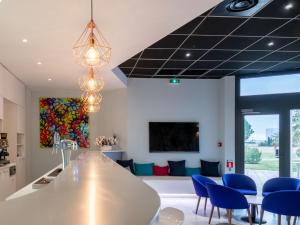 cocina y sala de estar con sillas azules en Sous Les Pins, en Étoile-sur-Rhône