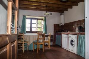 cocina con mesa, sillas y ventana en Casa de Aldea Casa de Isidoro, en Linares