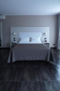 a bedroom with a large bed and two night stands at Hotel La Meridiana in Settimo Torinese