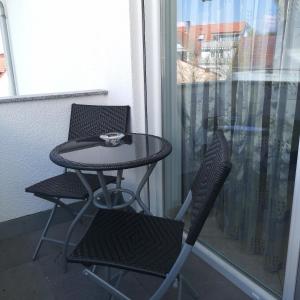 a small table and two chairs on a balcony at Ferienwohnung Noll in Friedrichshafen
