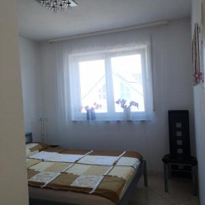 a bedroom with a bed and a window with flowers at Ferienwohnung Noll in Friedrichshafen