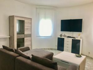 a living room with a couch and a tv at MEDDAYS VILLA NOAH in Miami Platja