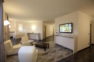 a living room with a flat screen tv on a wall at Hotel La Meridiana in Settimo Torinese