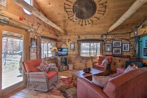 una sala de estar con sofás y TV en una cabaña de madera en Cabin on Private Island Less Than 6 Mi to Sand Valley Golf, en New Rome