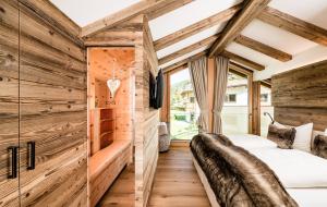 a bedroom with wooden walls and two beds at Paruda in Ortisei