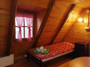 ein Schlafzimmer mit einem Bett in einem Blockhaus in der Unterkunft Chalet Four Seasons in Zlatibor