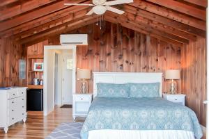 a bedroom with a bed and a wooden wall at Linekin Bay Resort in Boothbay Harbor