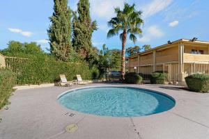 uma piscina com duas cadeiras e uma casa em La Quinta Inn by Wyndham Phoenix North em Phoenix