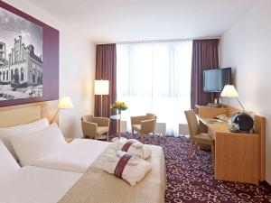 a hotel room with a bed and a desk at Mercure Hotel Dortmund City in Dortmund