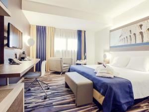 a hotel room with a bed and a desk at Mercure Roma Centro Colosseo in Rome
