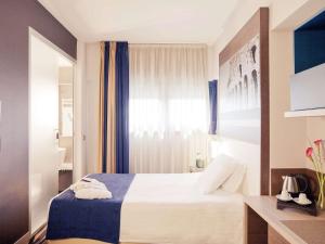 a hotel room with a bed and a window at Mercure Roma Centro Colosseo in Rome