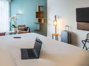 un ordinateur portable assis sur un comptoir blanc dans une pièce dans l'établissement Mercure Aix-les-Bains Domaine de Marlioz Hôtel & Spa, à Aix-les-Bains