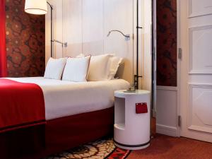 Cette chambre comprend un lit rouge et blanc. dans l'établissement Hotel Carlton Lyon - MGallery Hotel Collection, à Lyon